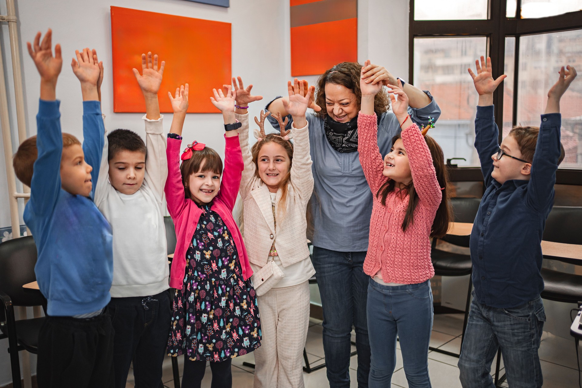Cherful teacher and  elementary students at language school class